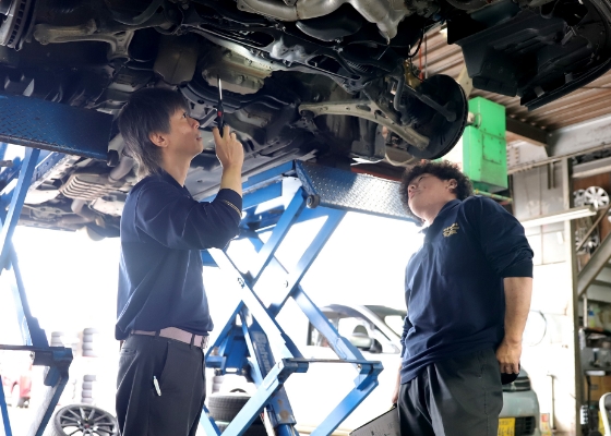リフト上の車両を点検する整備士
